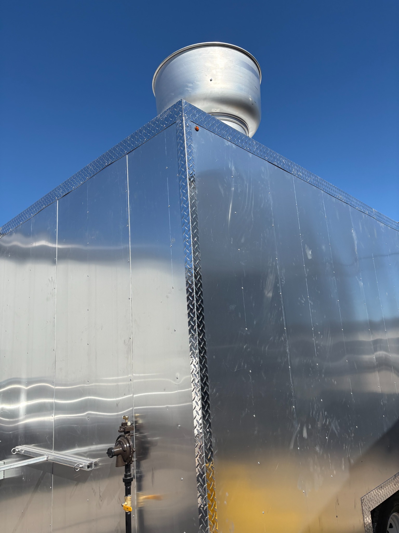 Rooftop exhaust vent at the corner of the trailer